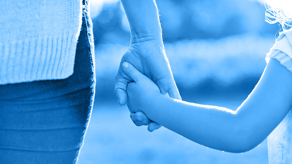 Röhm Symbolische Darstellung von Vertrauen – Erwachsener hält die Hand eines Kindes Röhm Erwachsene Hand hält die Hand eines Kindes – Symbol für Vertrauen und Sicherheit