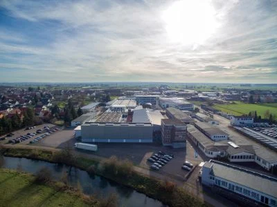 Röhm Moderne Industrieanlage aus der Luftperspektive – Produktionsstandort Röhm Luftaufnahme eines modernen Industriebetriebs mit Produktionshallen und Parkplätzen